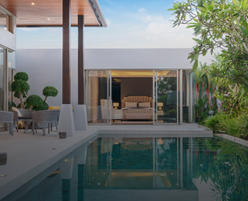 A straight-edged swimming pool with still, reflective water bordered by a minimalist grey deck.